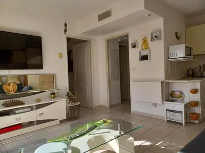 a living room with a tv and a glass table at L'escale à la French Riviera in Nice