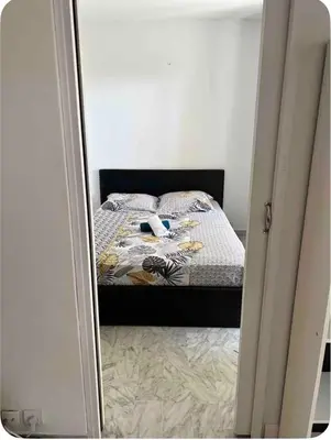 a mirror reflection of a bed in a bedroom at 2 pièces RDJ Proche Mer in Nice
