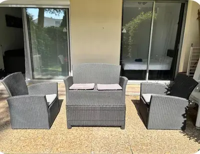 a group of wicker chairs sitting on a patio at 2 pièces RDJ Proche Mer in Nice