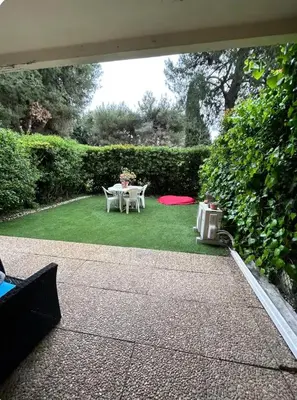 a patio with a table and chairs on the grass at 2 pièces RDJ Proche Mer in Nice