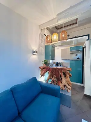 a living room with a blue couch and a kitchen at Midnight Blue - Heart of Nice - Breakfast - AC -Wi-Fi in Nice