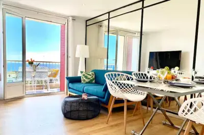 a living room with a blue couch and a table and chairs at Vue Mer Panoramique - Terrasse - Climatisation - 2 Bedrooms - Wifi - Cuisine - Tramway in Nice