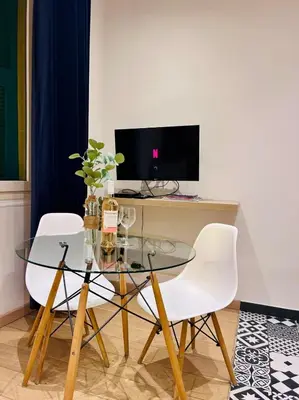a glass table with two white chairs and a television at Old Town Immersion-Breakfast-Central-Self Check-in in Nice