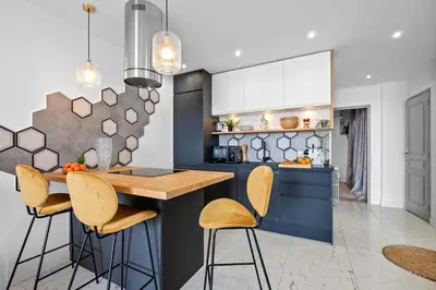 a kitchen with a blue island with bar stools at Baie des Anges in Nice