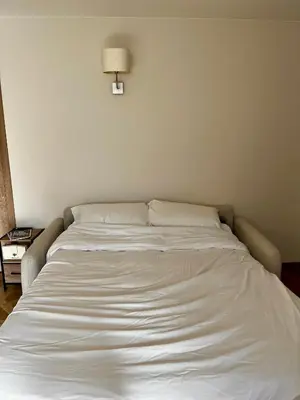 a white bed in a room with a lamp at Appartement Jasmin 2 pièces central à Cagnes-sur-Mer in Cagnes-sur-Mer