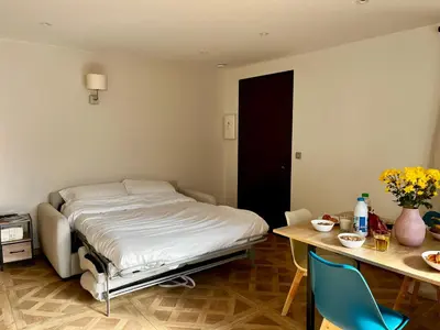 a bedroom with a bed and a desk and a table with chairs at Appartement Jasmin 2 pièces central à Cagnes-sur-Mer in Cagnes-sur-Mer