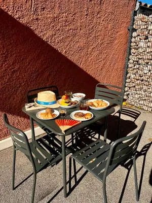 a table with plates of food on it with two chairs at Appartement Jasmin 2 pièces central à Cagnes-sur-Mer in Cagnes-sur-Mer