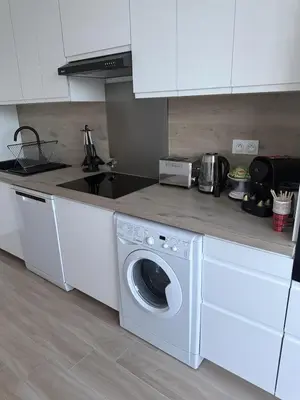 a kitchen with a washing machine and a counter at Deux pièces moderne avec balcon & Vue dégagée in Nice