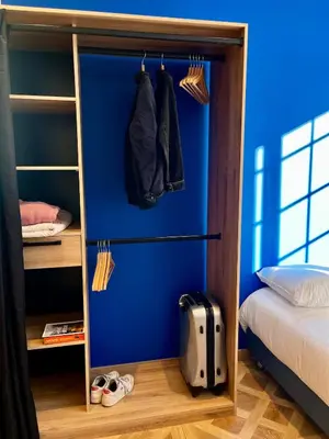 a bedroom with a blue wall and a closet with shoes at Oiseau du paradis studio central pour 4 personnes in Cagnes-sur-Mer