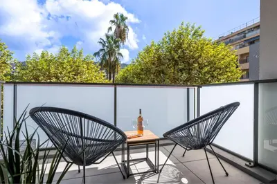 a glass balcony with a table and two chairs at Appartement du Port with park view in Nice