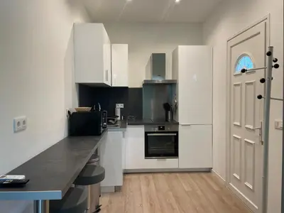 a kitchen with white cabinets and a black counter top at Beautiful studio with terrace - Nice Liberation in Nice