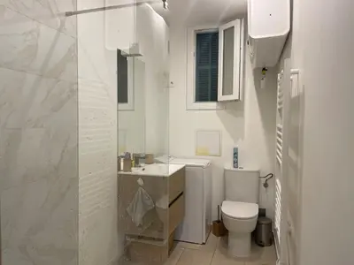 a white bathroom with a toilet and a sink at Beautiful studio with terrace - Nice Liberation in Nice