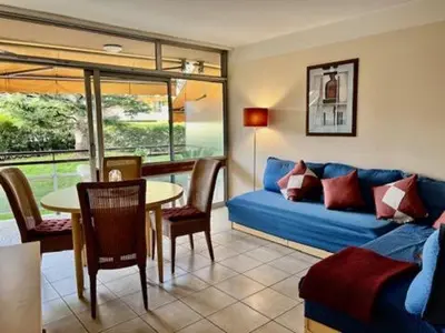 a living room with a blue couch and a table at Nice Seaside Appartement with Pool and Tennis in Saint-Laurent-du-Var