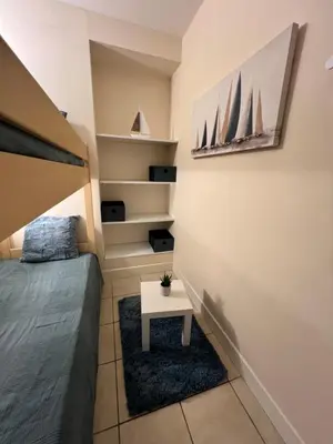 a small bedroom with a bed and a table at Nice Seaside Appartement with Pool and Tennis in Saint-Laurent-du-Var