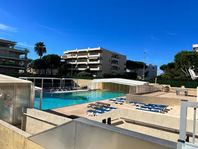 a swimming pool with lounge chairs and a building at Nice Seaside Appartement with Pool and Tennis in Saint-Laurent-du-Var