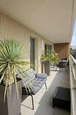 a balcony with a couch and potted plants on it at Luxury apartment with balcony & rooftop in Nice