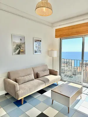 a living room with a couch and a view of the ocean at Vue mer panoramique, plage et Promenade à pied in Nice