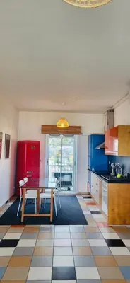a kitchen with a table and a red refrigerator at Vue mer panoramique, plage et Promenade à pied in Nice