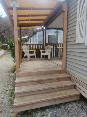 a wooden porch with two chairs on a house at Mobilhome Camping 4 étoiles in Cagnes-sur-Mer