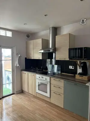 a kitchen with wooden cabinets and a stove top oven at 3 Pièces avec Terrasse sans vis à vis in Nice