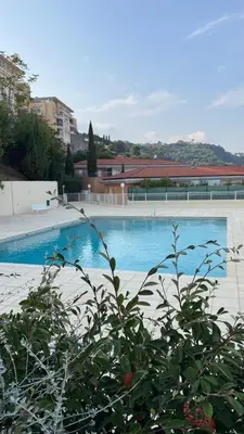 a large swimming pool with blue water at Appartement 3 chambres avec piscine et parking privé in Nice