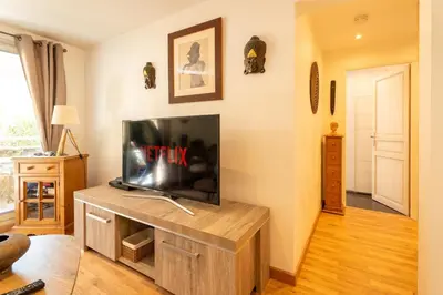 a living room with a flat screen tv on a entertainment center at Le Bougainvillier in Nice