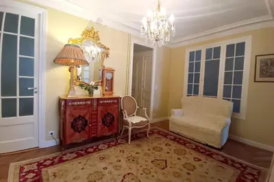 a living room with a chair and a mirror at Large bright apartment in the heart of Nice in Nice