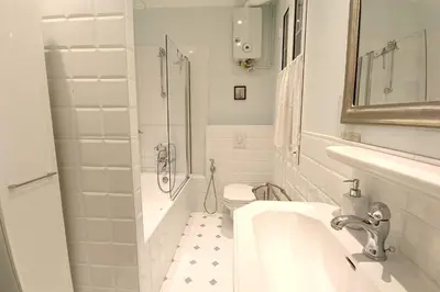 a white bathroom with a sink and a shower at Large bright apartment in the heart of Nice in Nice