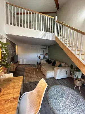 a living room with a staircase and a couch at Duplex close to the sea with parking in Nice
