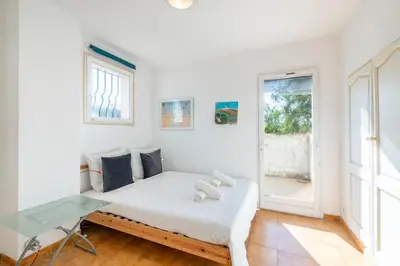 a white bedroom with a bed and a glass desk at Villa in Cagnes-sur-Mer in Cagnes-sur-Mer