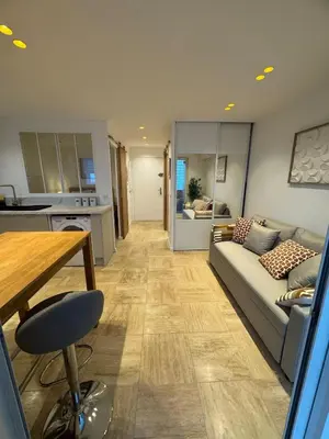 a living room with a couch and a table and a kitchen at Le California front de mer in Cagnes-sur-Mer