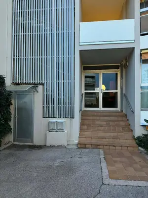 a building with a door and stairs in front of it at Le California front de mer in Cagnes-sur-Mer