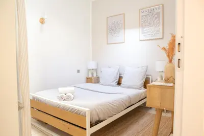 a bedroom with a bed with white sheets at Duplex carré d'or au calme sur cour 100m de la plage in Nice