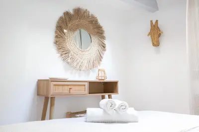 a bedroom with a mirror and a table with towels at Duplex carré d'or au calme sur cour 100m de la plage in Nice