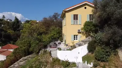 a yellow house on the side of a hill at House on the Hill in Nice