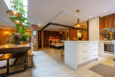 a kitchen with white cabinets and a living room at Loft proche du port de Nice - 6 pers - Parking in Nice