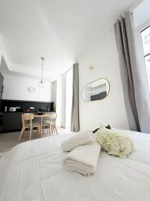 a white bedroom with a bed with towels on it at Lympia Riviera Residence in Nice