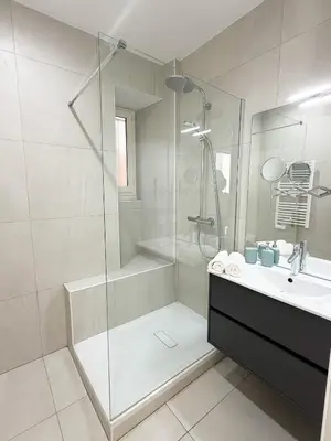 a white bathroom with a shower and a sink at Lympia Riviera Residence in Nice