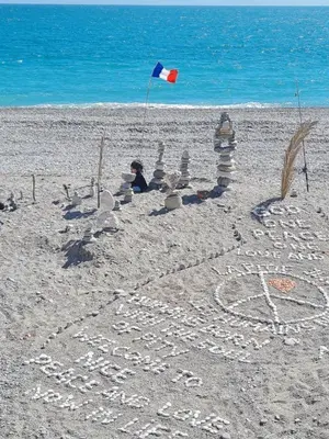 a child is making a sand castle on the beach at Lympia Riviera Residence in Nice