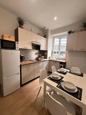 a kitchen with white cabinets and a table and chairs at Moderne 3 chambres, 2 douches, proche gare, wifi in Nice
