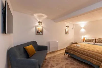 a bedroom with a bed and a couch and a chair at La Maison Du Pêcheur in Cagnes-sur-Mer