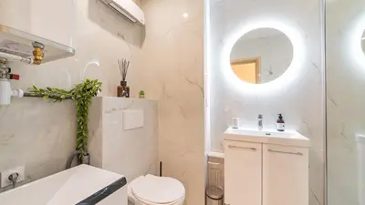 a bathroom with a toilet and a sink and a mirror at B G Cocon Meyerbeer 2 - Grimaldi Promenade des Ang in Nice