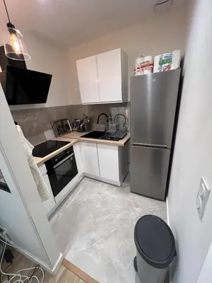 a small kitchen with a stainless steel refrigerator at Appartement vieux Nice in Nice