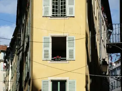 a building with a window with a flower pot in it at Place Rossetti - Charming Apartment in Nice