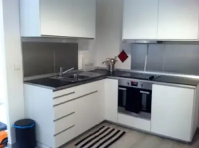a kitchen with white cabinets and a sink and a stove at Place Rossetti - Charming Apartment in Nice