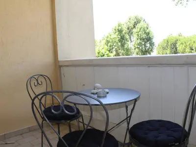 a small table and two chairs on a balcony at Appartement refait à neuf, climatisé - familles - FR-1-252A-143 in Cagnes-sur-Mer