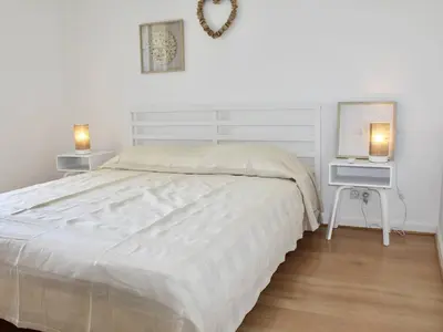 a white bedroom with a bed and a desk with a computer at Appartement refait à neuf, climatisé - familles - FR-1-252A-143 in Cagnes-sur-Mer