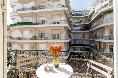 a vase of flowers sitting on a table on a balcony at Wide & Central 3 Bdr - AC & Balcony in Nice