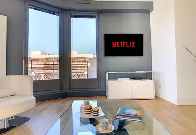 a living room with a couch and a tv on a wall at Nestor&Jeeves - LES AIGLES - Very close sea - Top floor - Luxurious in Nice