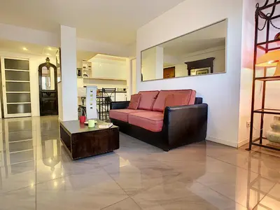 a living room with a red couch and a table at Nestor&Jeeves - SUITE ROYAL LUXEMBOURG - Central - Swimming pool on roof in Nice